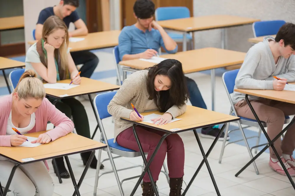 Candidati seduti ai banchi durante la prova scritta del concorso pubblico per Allievi Carabinieri in aula d'esame.
