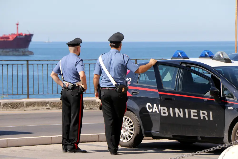 Carabinieri di un reparto speciale in addestramento tattico costiero accanto alla propria auto di servizio.