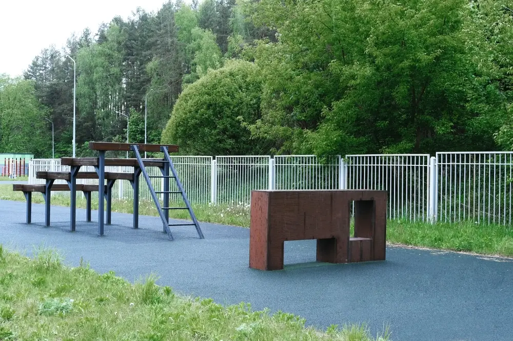 Ostacoli in legno su pista azzurra per l'attrezzatura ginnica e la preparazione fisica in un'area militare all'aperto.