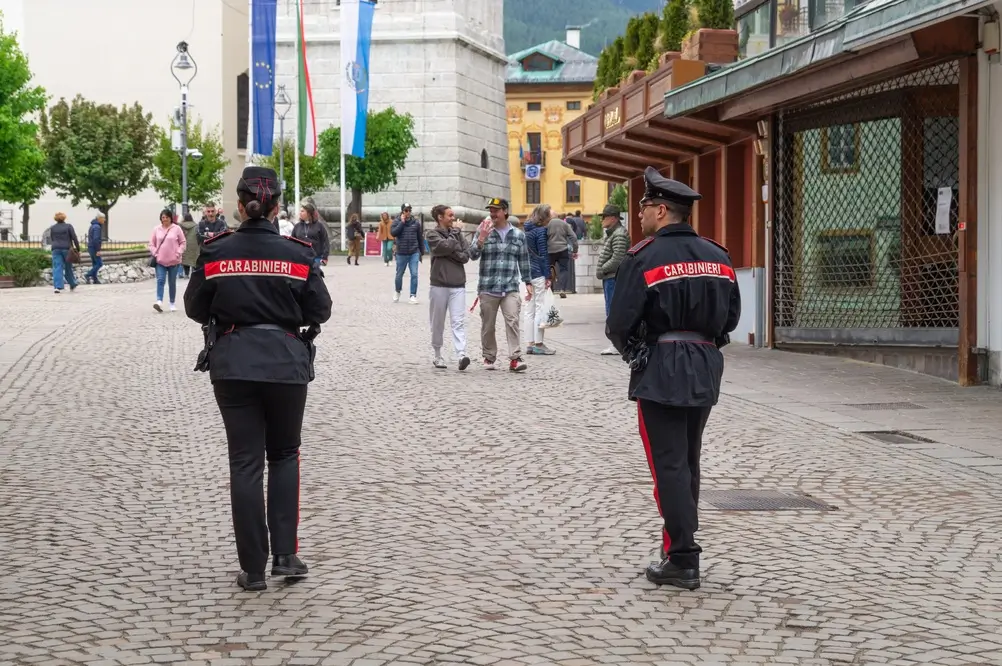Carabinieri in pattuglia a piedi nel centro di una città italiana per il servizio di controllo del territorio.