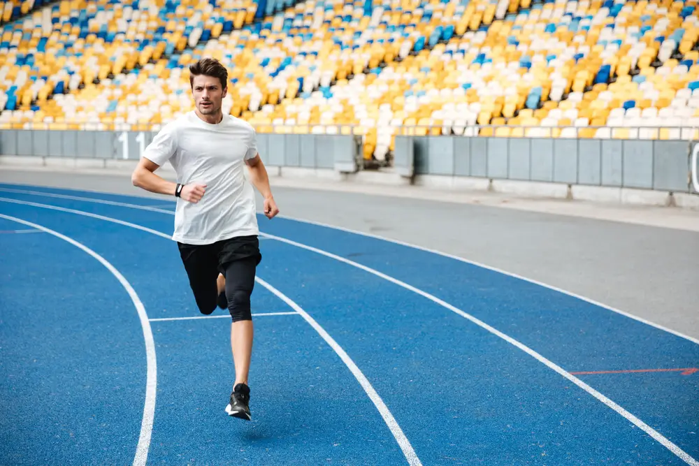 Candidato impegnato nella prova di corsa su pista blu durante un test di efficienza fisica.