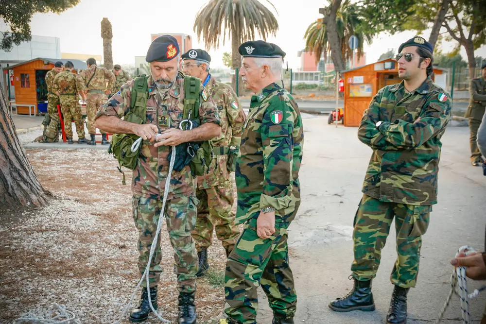 Sessione di formazione militare per allievi carabinieri: istruttori e reclute durante l'addestramento tecnico in caserma.