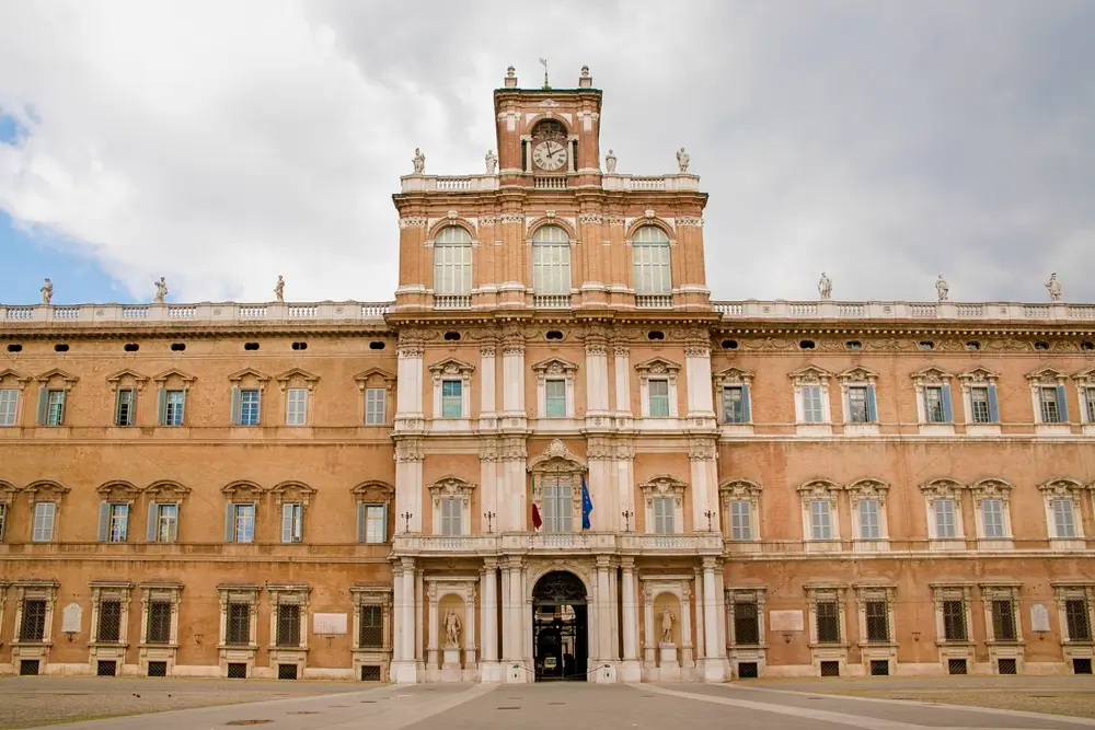 Facciata del Palazzo Ducale di Modena, sede storica dell'Accademia Militare, con torre centrale e orologio.