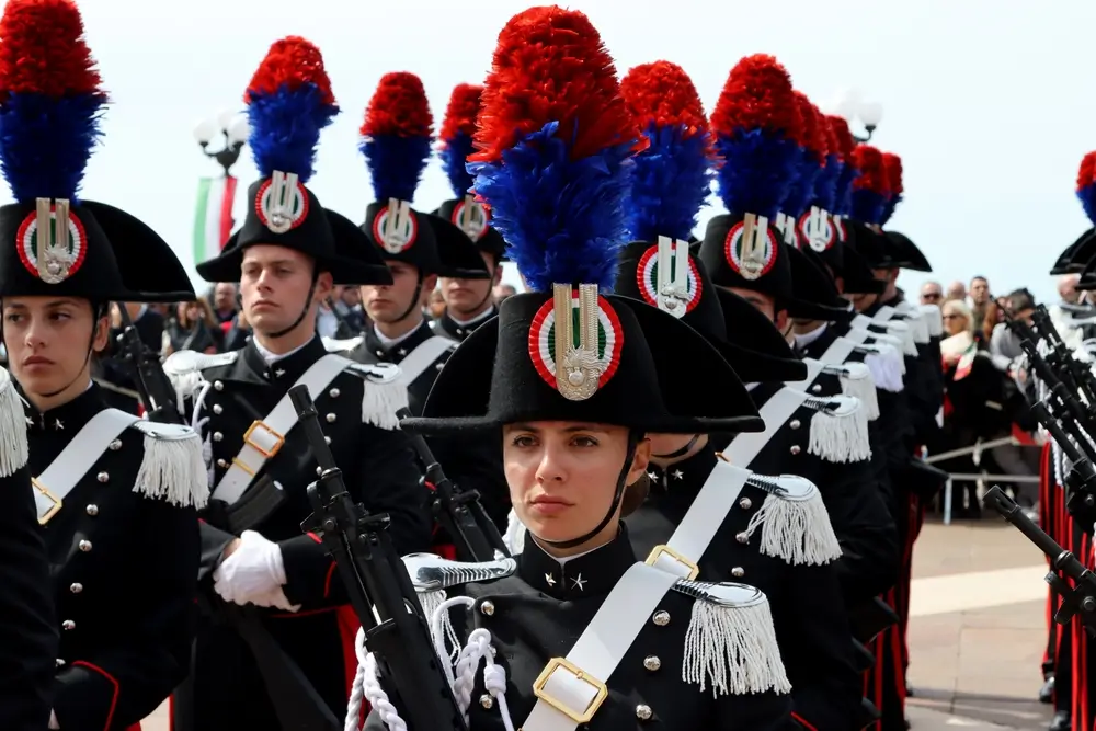 Carabinieri in Grande Uniforme Speciale con pennacchio rosso e blu durante una cerimonia ufficiale.