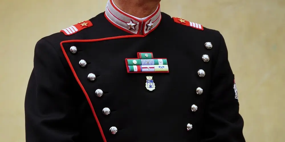 Primo piano degli alamari e dei fregi sulla divisa di un carabiniere durante la cerimonia del giuramento solenne.