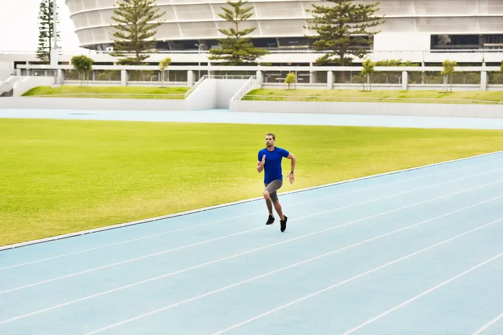 Candidato in corsa su una pista di atletica durante un allenamento per le prove fisiche di selezione.