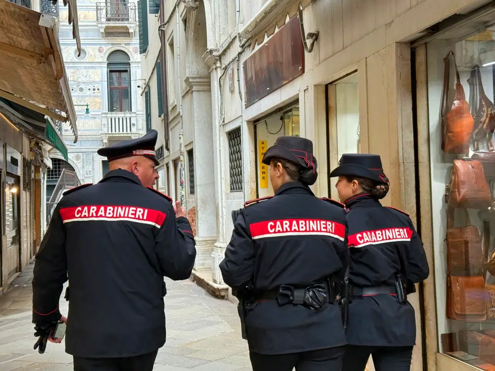 Una pattuglia di carabinieri in servizio a piedi percorre le strade di una città per il controllo del territorio.