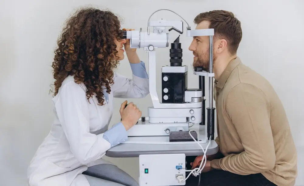 Oculista esegue una visita oculistica per il controllo della vista a un candidato tramite lampada a fessura.