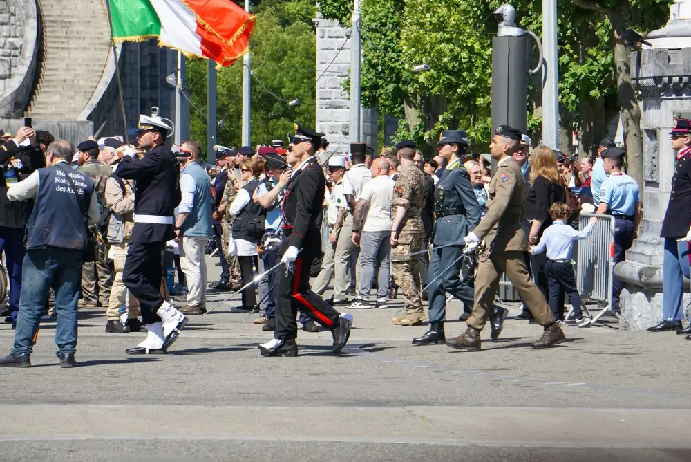 Un ufficiale dei Carabinieri sfila in alta uniforme con la bandiera italiana durante una cerimonia militare.